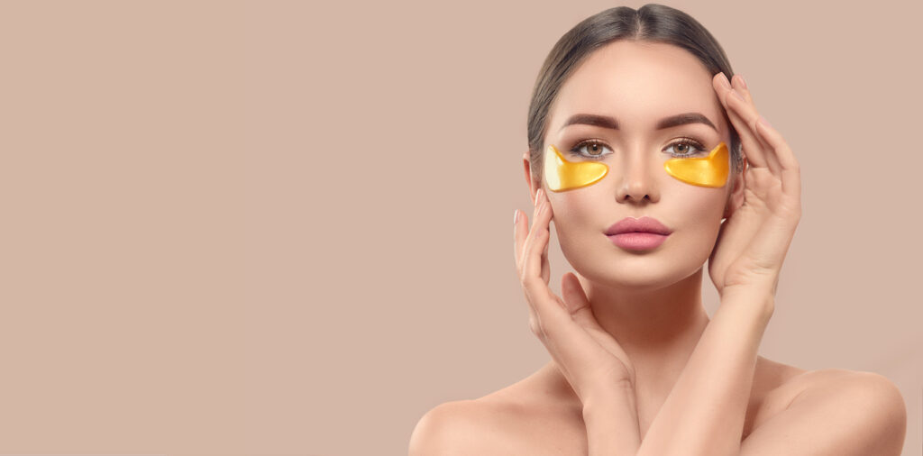 Kvinne med eye pads og brunt hår mot beige bakgrunn